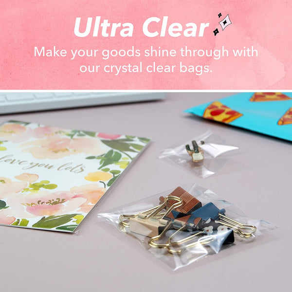 Clear plastic bags packaging gold paper clips on a pink background with text 'Ultra Clear'.