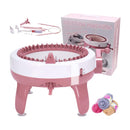 Pink knitting machine with accessories and yarn on a white background